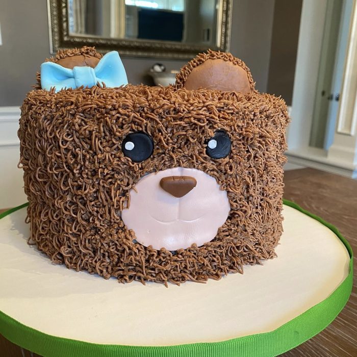 Teddy bear cake with piped buttercream fur and a blue bow